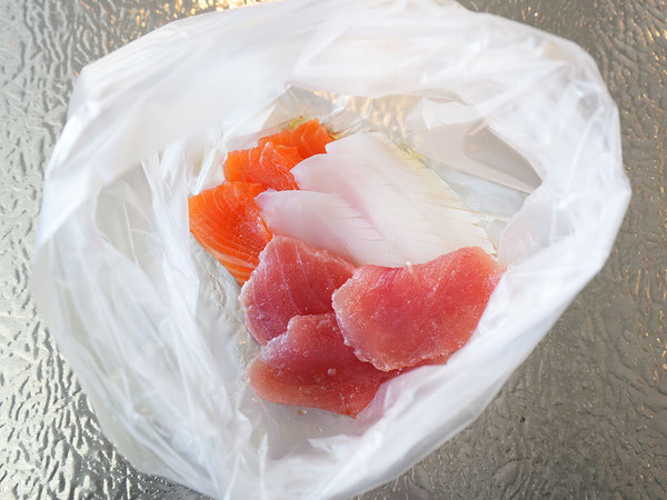 將金槍魚、魷魚、鮭魚和白高湯放入塑料袋中的場景 [2]